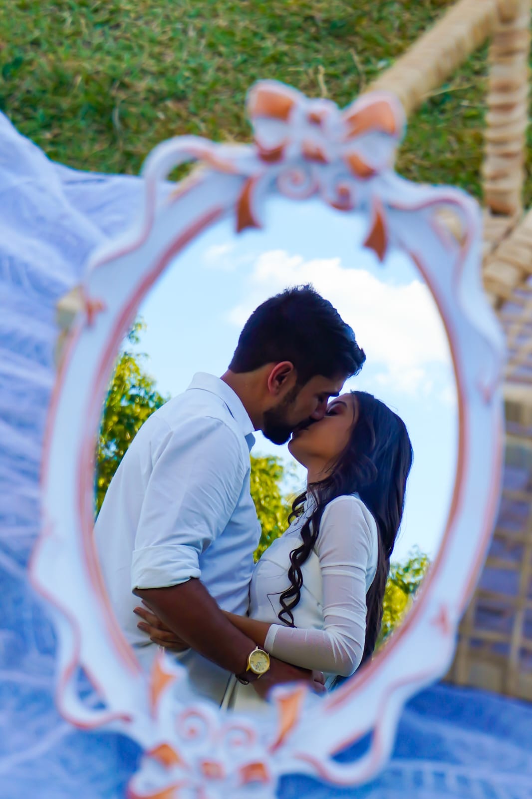 Laila e Luiz se beijando refletidos em um espelho decorado